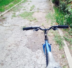 Picture of blue bike on concrete path. 