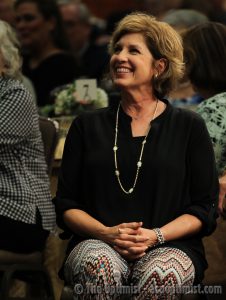 Mrs. Lucado smiles up at her husband as he speaks at Monday's dinner. (Photo by Lydia Lawson)