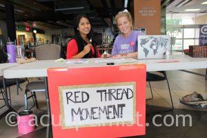 Rita Rodriguez and Kalli Moyer help design henna tattoos for the Red Thread Movement fundraiser
