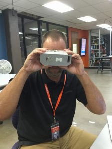 Darren Wilson, maker lab coordinator, shows how the VR goggles are supposed to be operated. 